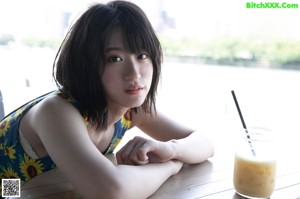 A woman in a green bikini sitting on the floor.