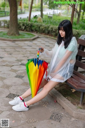 A woman in a raincoat holding an umbrella.