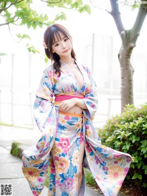 A woman in a blue kimono posing for a picture.