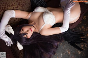 A woman in lingerie sitting on a chair in a room.