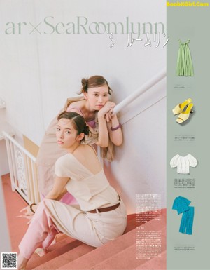 A couple of women sitting on top of a set of stairs.