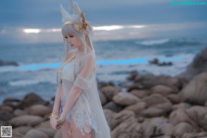 A woman in a white bikini standing on a beach.