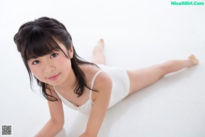 A young girl sitting on the floor with a hula hoop.