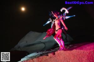 A woman in a futuristic outfit sitting on the ground.