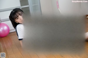 A woman standing in a room with a hula hoop.