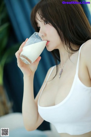 A woman in a white bra and panties sitting on the floor.