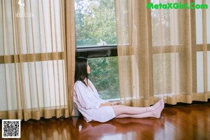 A woman is sitting on the stairs of a house.