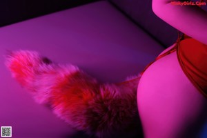 A woman in a red lingerie sitting on a table.