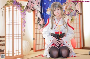 A woman in a kimono sitting on the floor.