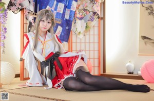 A woman in a kimono sitting on the floor.