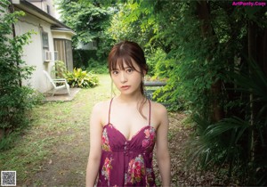 A woman in a purple dress is posing for a picture.