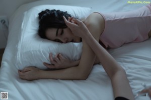 A woman in a pink top and shorts standing on a bed.