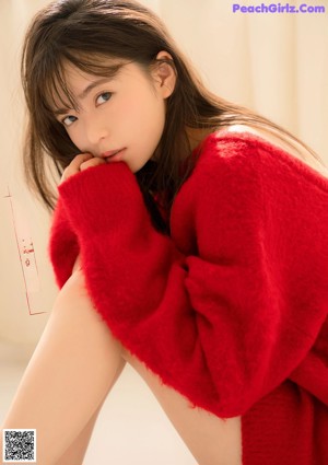 A magazine with a picture of a woman in a red sweater.