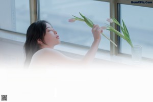 A woman sitting in a white bird cage.