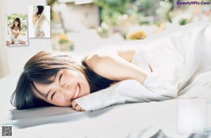 A woman laying on a bed covered in white sheets.