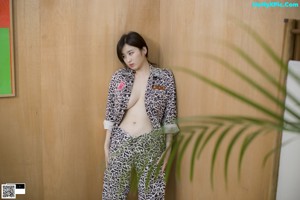 A woman standing next to a woman in a leopard print pajamas.