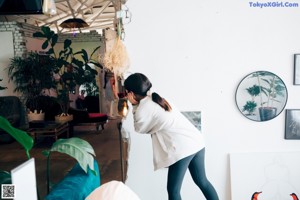 A woman sitting on top of a bed next to a mirror.