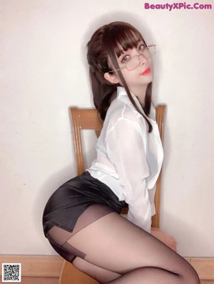 A woman wearing a white shirt and glasses.