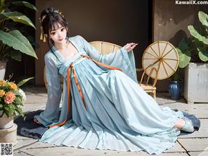 A woman in a blue dress sitting on a window sill.