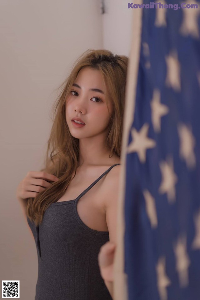A woman standing in front of an American flag.