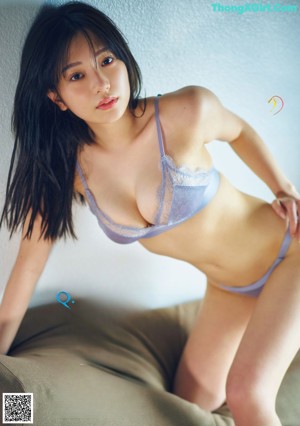 A woman in a blue bikini posing for a magazine.