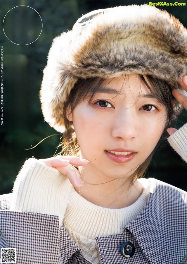 A woman wearing a fur hat is posing for a magazine.