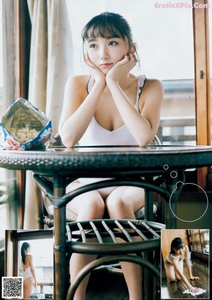 A young woman leaning against a brick wall.