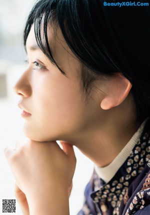 A woman sitting on a window sill in front of a window.