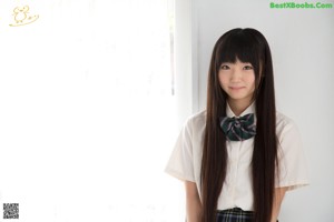 A young woman with long black hair wearing a school uniform.