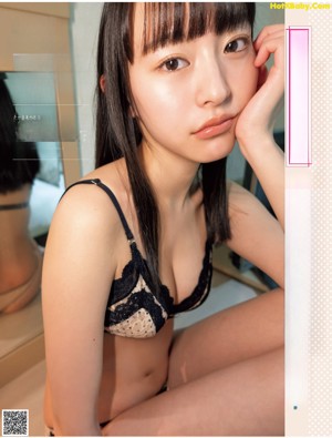 A woman in a blue bikini is taking a shower.